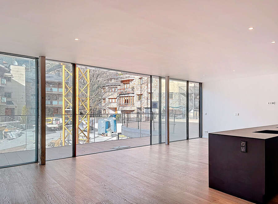 Stunning open-plan living space with floor-to-ceiling windows offering breathtaking mountain views.