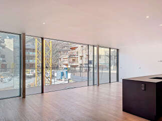 Stunning open-plan living space with floor-to-ceiling windows offering breathtaking mountain views.
