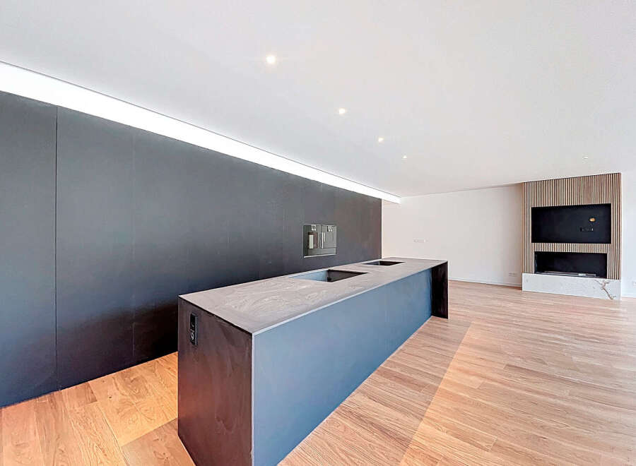 Modern kitchen island with sleek dark countertop and integrated appliances.