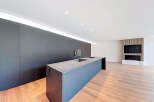 Modern kitchen island with sleek dark countertop and integrated appliances.