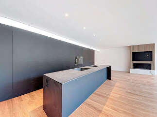 Modern kitchen island with sleek dark countertop and integrated appliances.