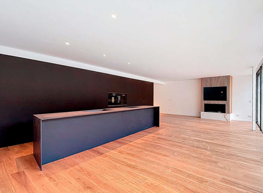 Stunning open-plan living space with sleek, modern kitchen island and hardwood floors.