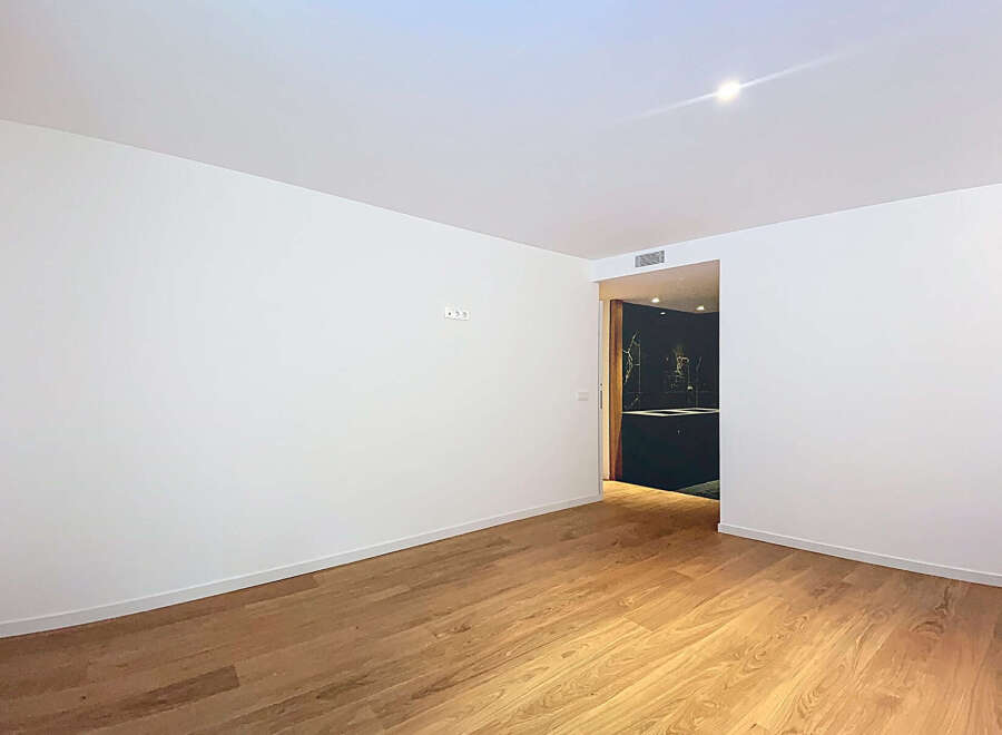 This stunning property boasts a spacious, bright living area with gleaming hardwood floors and crisp white walls.