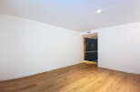 This stunning property boasts a spacious, bright living area with gleaming hardwood floors and crisp white walls.