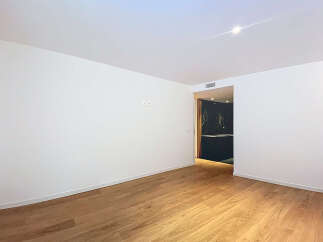 This stunning property boasts a spacious, bright living area with gleaming hardwood floors and crisp white walls.