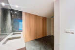 Luxurious bathroom boasts double sinks with marble countertops and dark marble wall tiles.