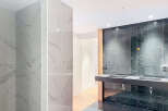 Luxury bathroom boasts modern marble tiling, sleek countertops, and recessed lighting.