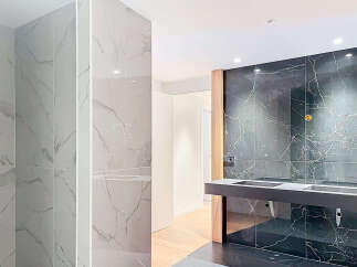 Luxury bathroom boasts modern marble tiling, sleek countertops, and recessed lighting.