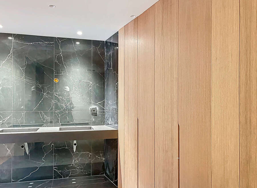 Luxury bathroom boasts a stunning dark marble wall and sleek, modern double vanity.