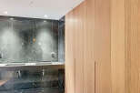 Luxury bathroom boasts a stunning dark marble wall and sleek, modern double vanity.