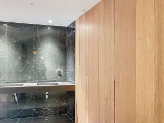 Luxury bathroom boasts a stunning dark marble wall and sleek, modern double vanity.