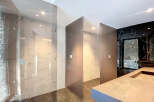 Luxury bathroom boasts stunning marble tile and sleek glass partitions, creating a spa-like atmosphere.