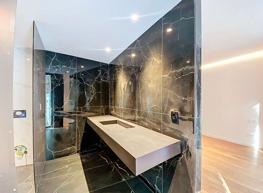 Modern bathroom with floating vanity and dark marble tile.