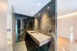 Modern bathroom with floating vanity and dark marble tile.