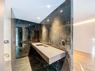 Modern bathroom with floating vanity and dark marble tile.