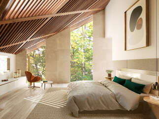 Luxurious bedroom with sloped ceilings and large windows offering abundant natural light and forest views.