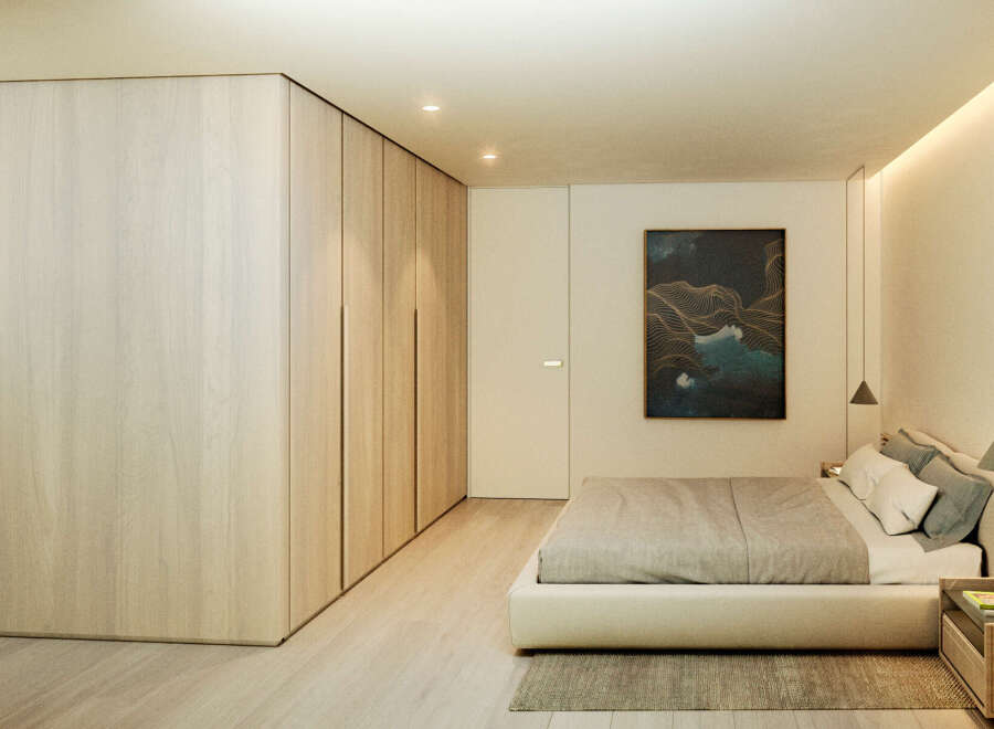 This stunning bedroom boasts a minimalist design with built-in light wood wardrobes and a plush platform bed.