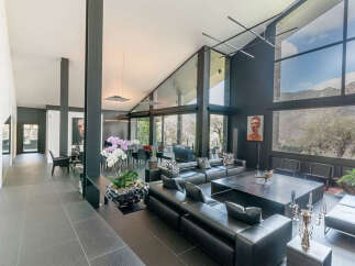 This stunning contemporary home boasts an open floor plan with floor-to-ceiling windows offering breathtaking mountain views.