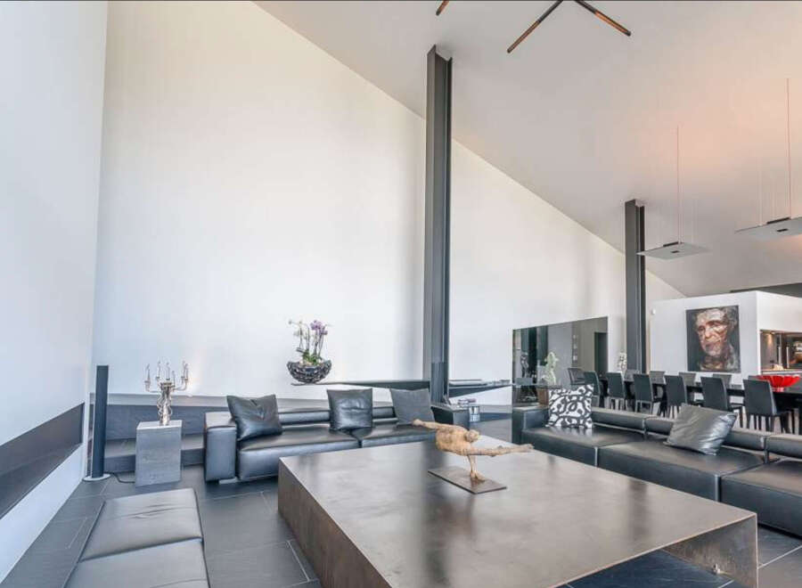 This stunning modern home boasts an open-concept living area with soaring ceilings and sleek, minimalist design.