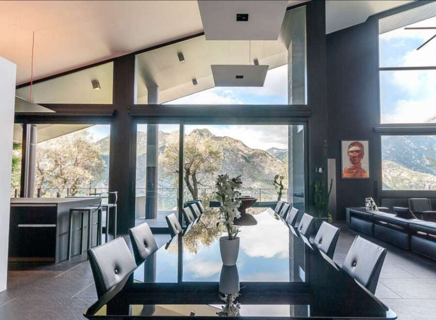 Modern mountain villa with floor-to-ceiling windows offering breathtaking views.