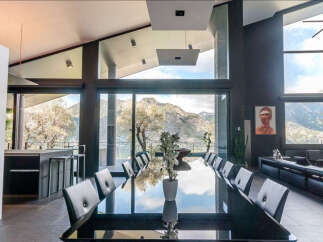 Modern mountain villa with floor-to-ceiling windows offering breathtaking views.