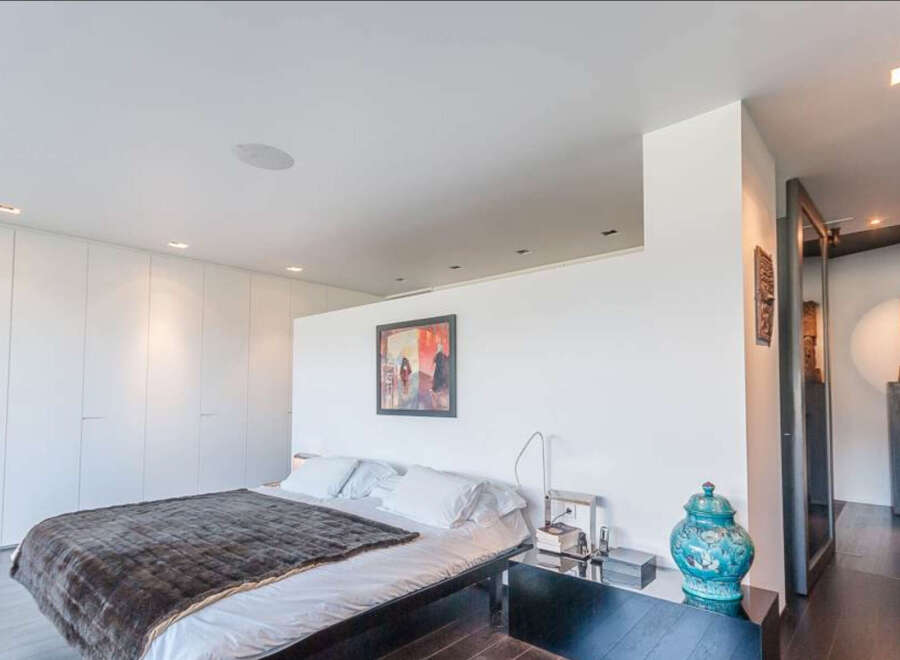 Luxurious modern bedroom with built-in wardrobes and stunning city views.