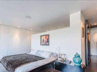 Luxurious modern bedroom with built-in wardrobes and stunning city views.