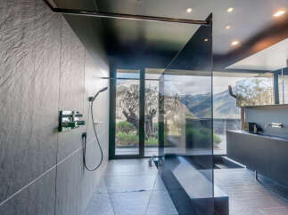 Indulge in this luxurious bathroom featuring a walk-in shower with stunning mountain views.