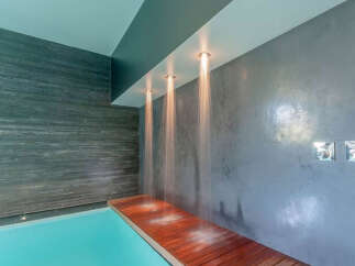 Indulge in ultimate luxury with this stunning indoor pool featuring a built-in rain shower system.