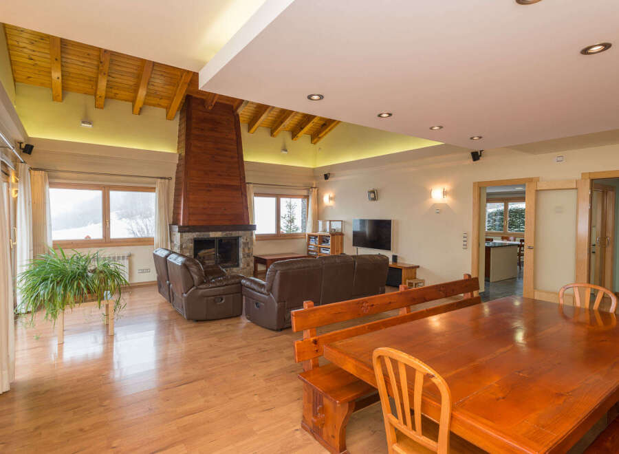 This stunning chalet boasts a spacious open-plan living area with a cozy fireplace, perfect for relaxing after a day on the slopes.