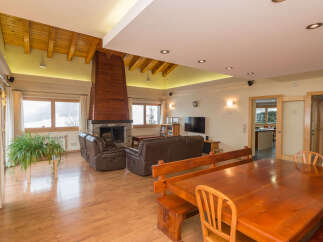 This stunning chalet boasts a spacious open-plan living area with a cozy fireplace, perfect for relaxing after a day on the slopes.