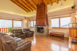 This stunning chalet boasts a spacious living area with floor-to-ceiling windows offering breathtaking mountain views.