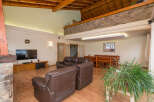 This stunning property boasts a spacious open-plan living area with high ceilings and exposed wooden beams, creating a warm and inviting atmosphere.