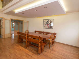 This stunning property boasts a spacious dining area with a large wooden table and built-in benches, perfect for family gatherings.