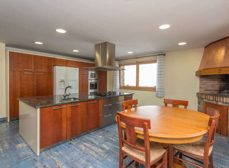 This stunning kitchen boasts granite countertops, wooden cabinetry, and stainless steel appliances.