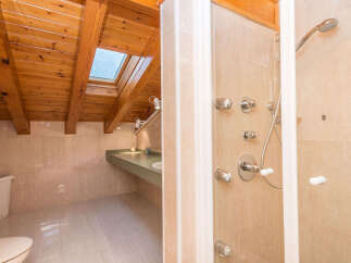 This luxurious bathroom boasts a spacious shower with multiple shower heads and a sleek, modern design.