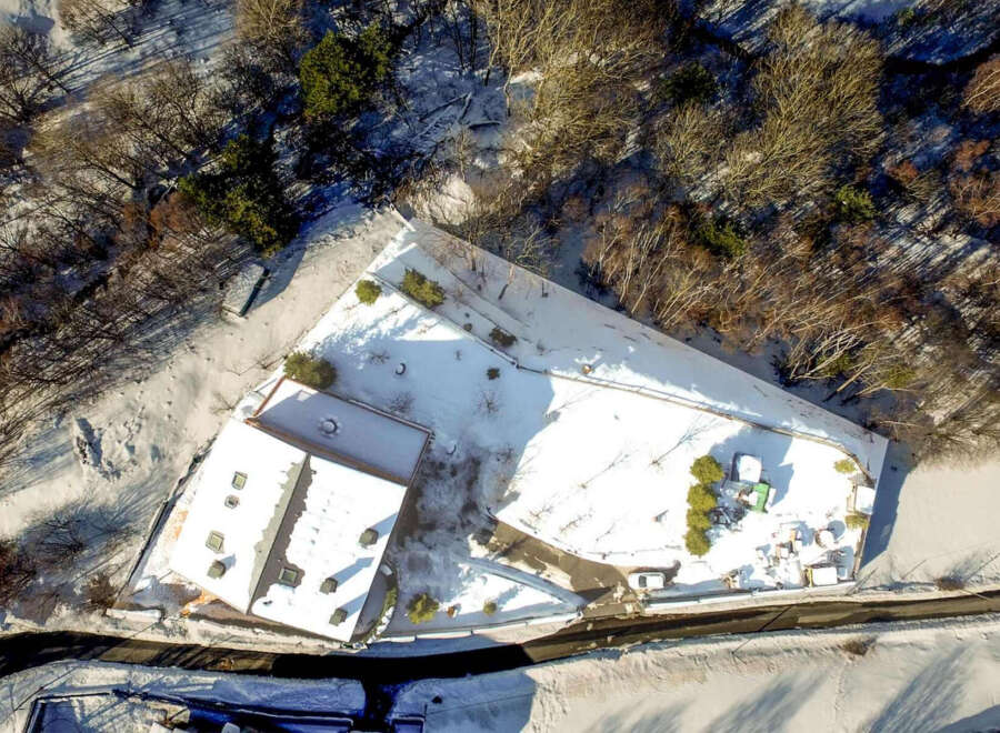 Nestled in a snow-covered landscape, this property boasts a spacious building with a unique architectural design.