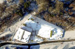 Nestled in a snow-covered landscape, this property boasts a spacious building with a unique architectural design.