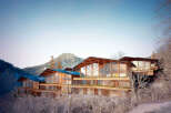 Stunning mountaintop home with expansive windows offering breathtaking views.