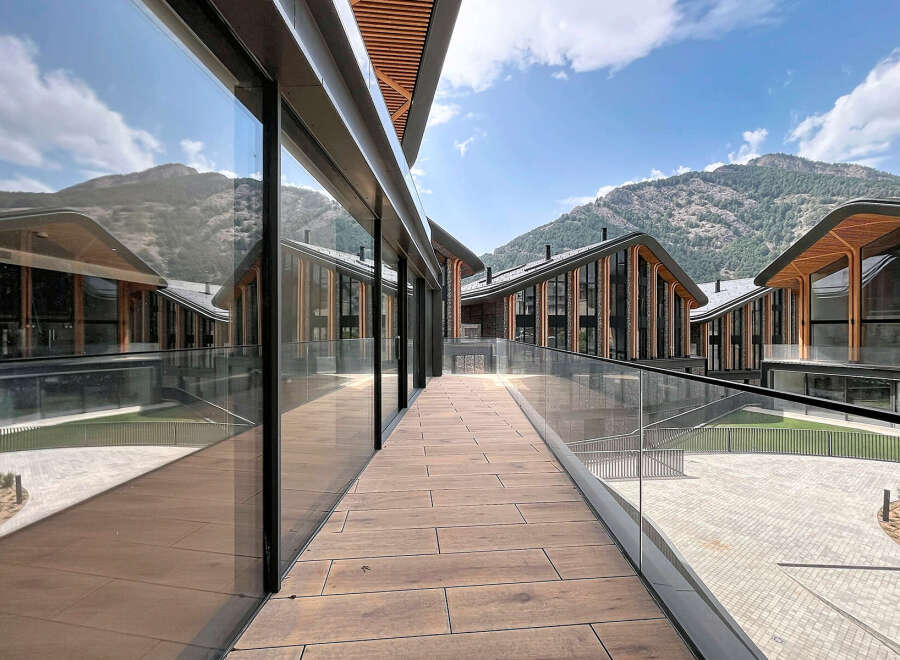 Experience modern luxury in this stunning architectural masterpiece, featuring expansive glass facades that beautifully reflect the surrounding mountainous landscape.