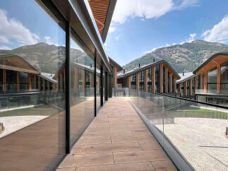 Experience modern luxury in this stunning architectural masterpiece, featuring expansive glass facades that beautifully reflect the surrounding mountainous landscape.