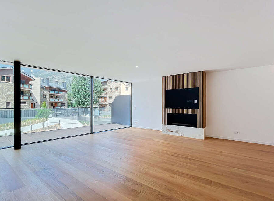 Experience modern living in this spacious, light-filled room featuring a sleek entertainment center with a built-in fireplace and elegant marble accents.