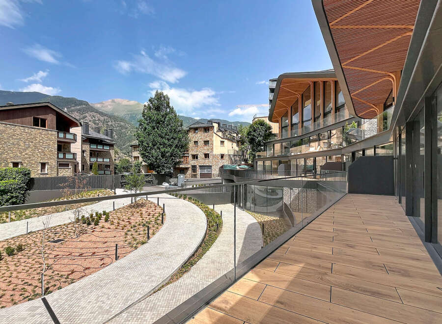 Discover modern living in this stunning property featuring a unique curved facade with a wooden slatted roof, offering panoramic mountain views.