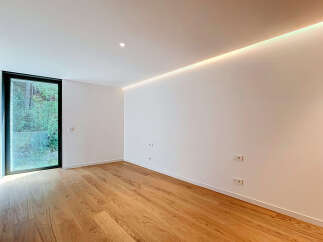 Experience modern living in this bright and airy room featuring a large floor-to-ceiling window that floods the space with natural light.