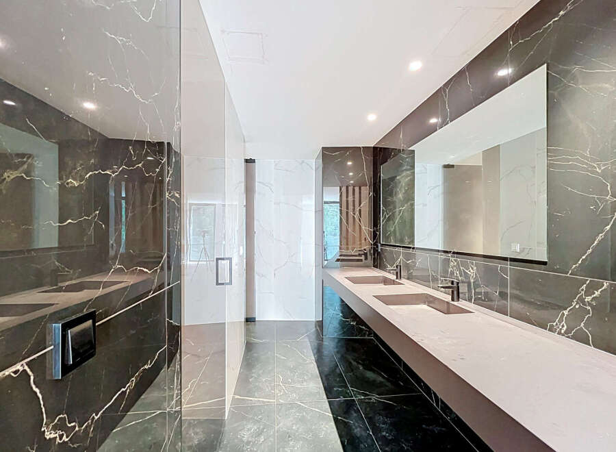 Experience modern luxury in this stunning bathroom featuring a sleek double vanity with integrated sinks and contemporary faucets.