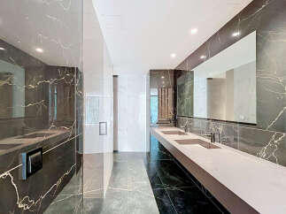 Experience modern luxury in this stunning bathroom featuring a sleek double vanity with integrated sinks and contemporary faucets.