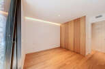 Experience modern living in this beautifully designed room featuring a sleek, built-in wooden wardrobe that offers ample storage.