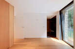 Experience modern living in this spacious room featuring a sleek wooden wardrobe and a minimalist interior.