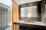 Experience modern luxury in this stunning bathroom featuring a sleek vanity with an integrated sink, complemented by dramatic black marble walls.