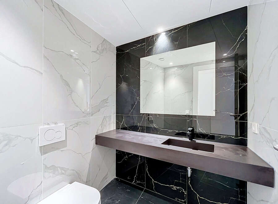 Experience modern luxury in this stunning bathroom, featuring elegant marble-patterned tiles on the walls and floor.